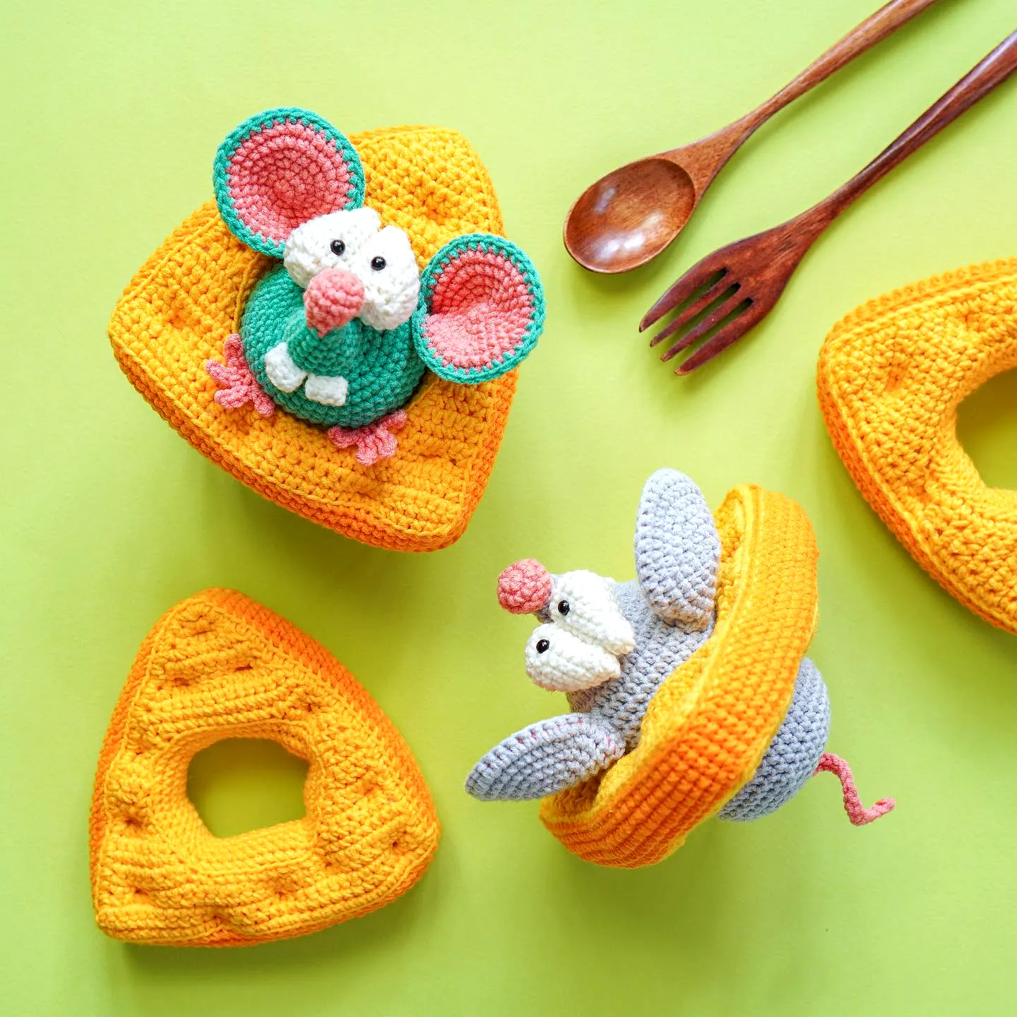 Adorable colorful crochet toy mice peeking from cheese wedges