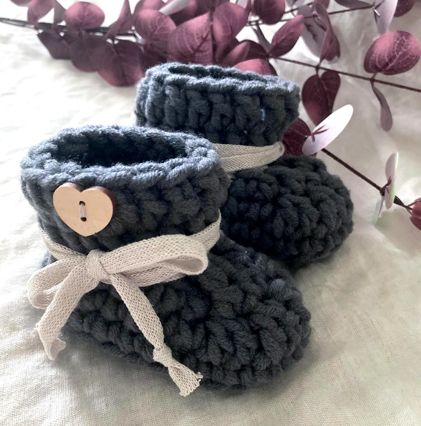 Adorable crochet baby booties in cozy grey with ribbon tie