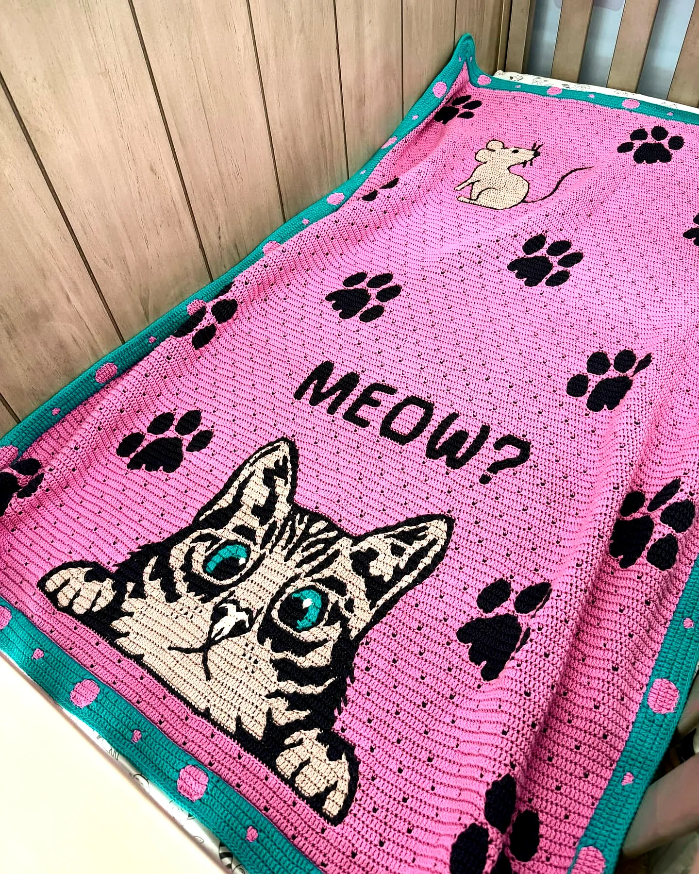 Adorable crochet pet blanket in soft pink with playful motifs