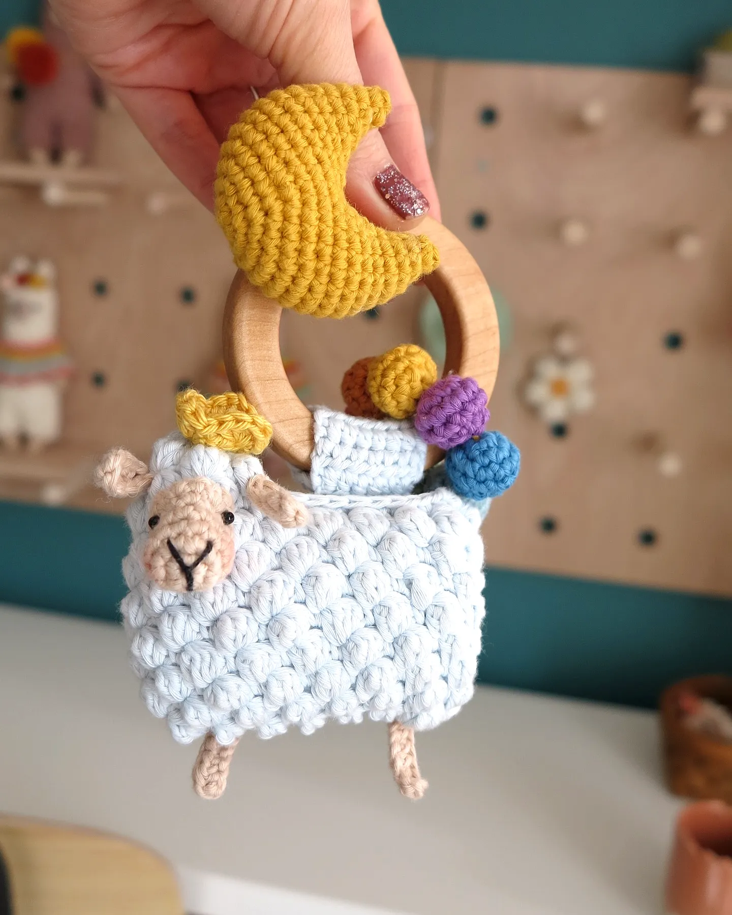 Adorable crochet rattle in soft blue with colorful elements