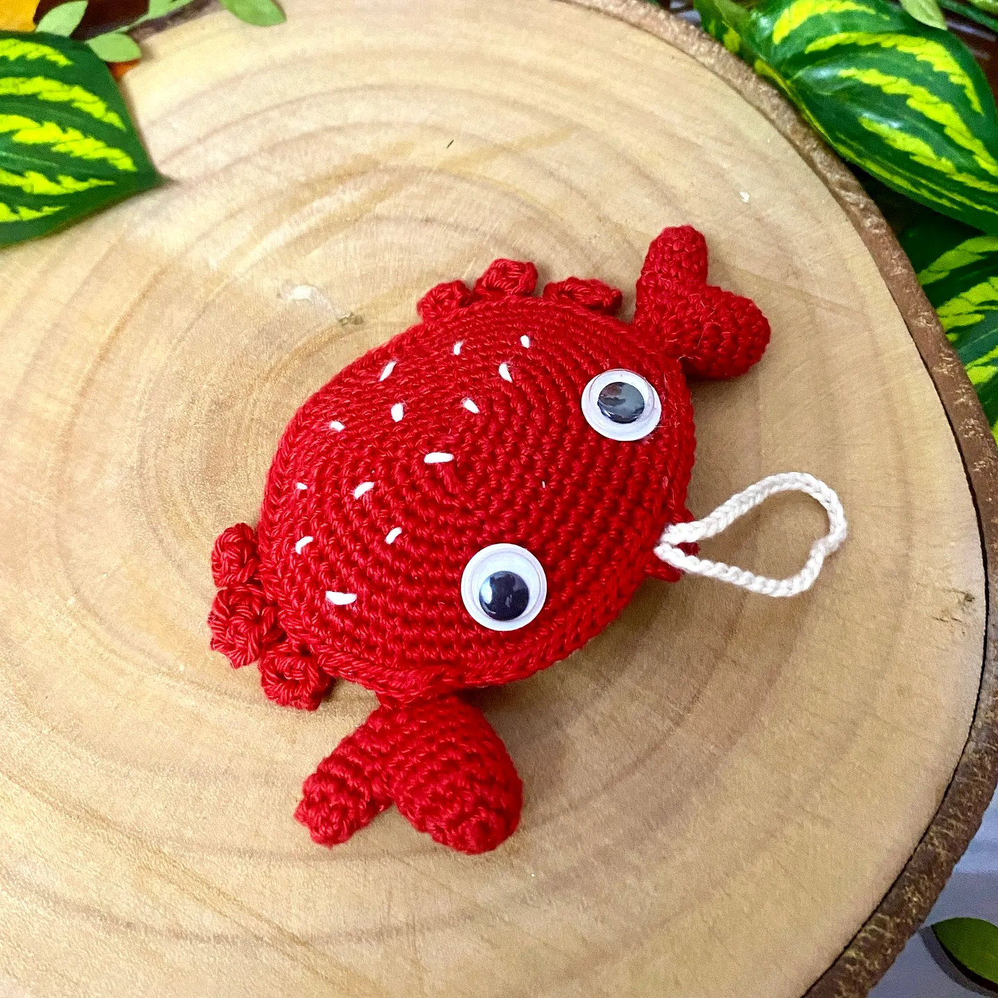 Adorable vibrant red crochet crab with playful googly eyes