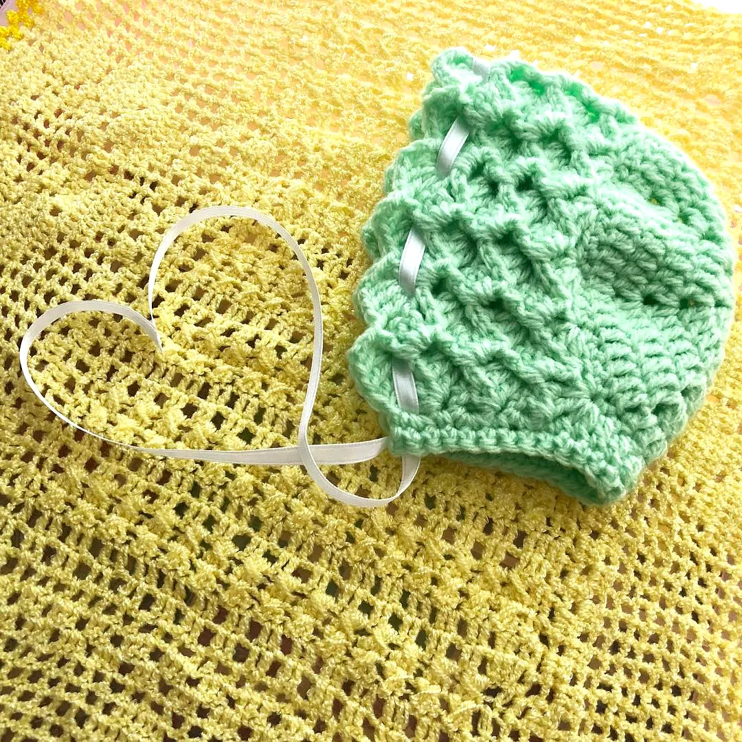 Charming mint green crochet baby bonnet with scalloped edge