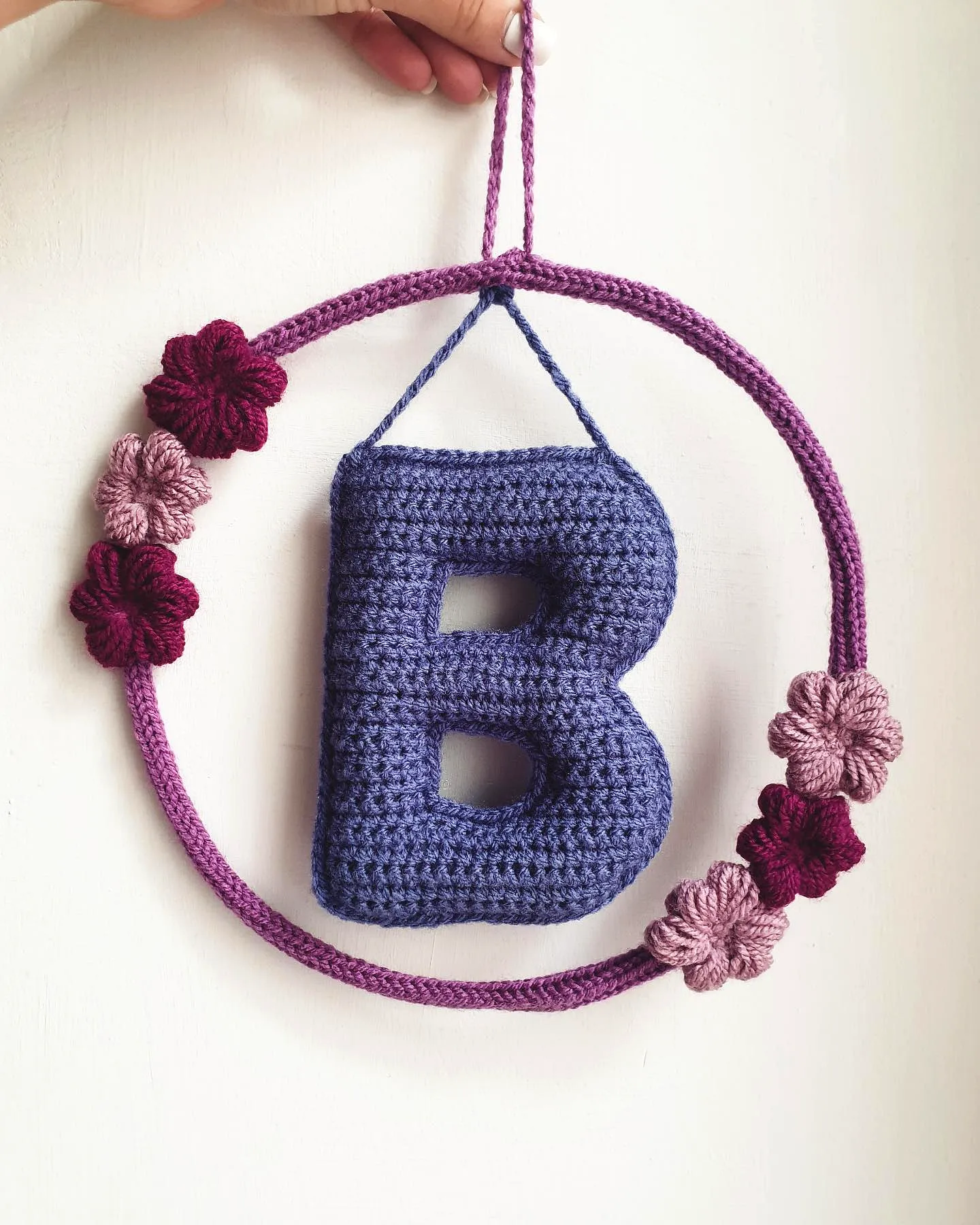 Colorful crochet nursery decor with purple and burgundy blooms