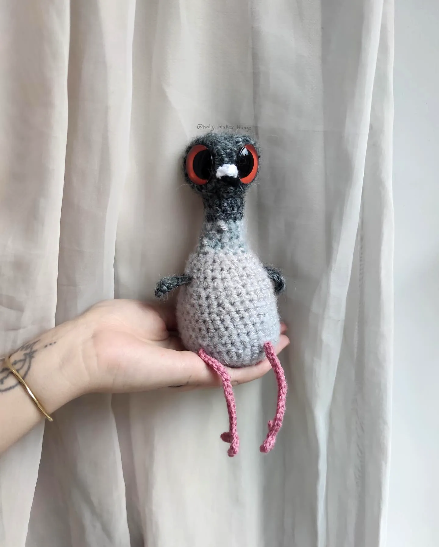 Cute crochet bird toy in gray and white with red eyes