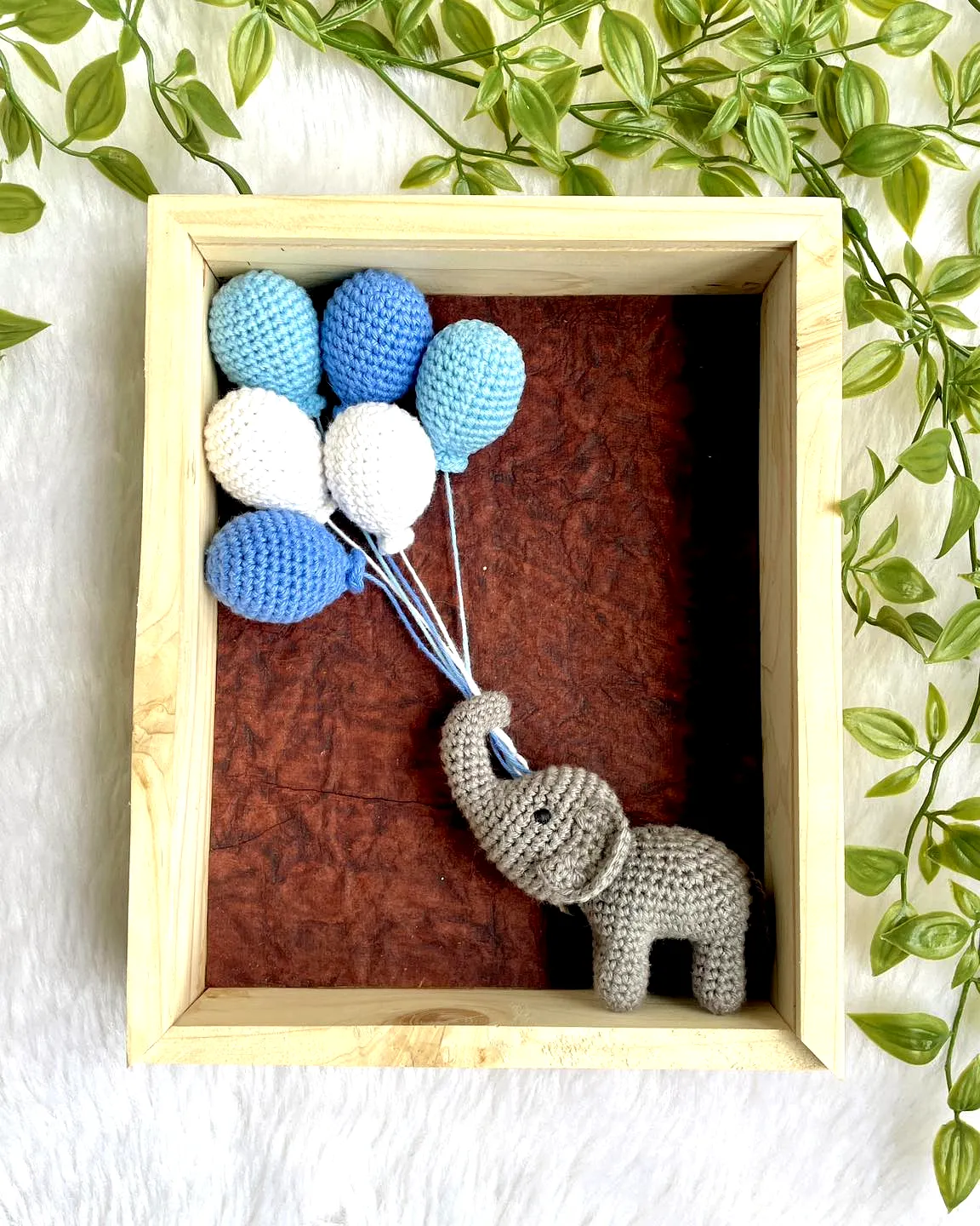 Cute gray elephant crochet nursery decor with blue balloons