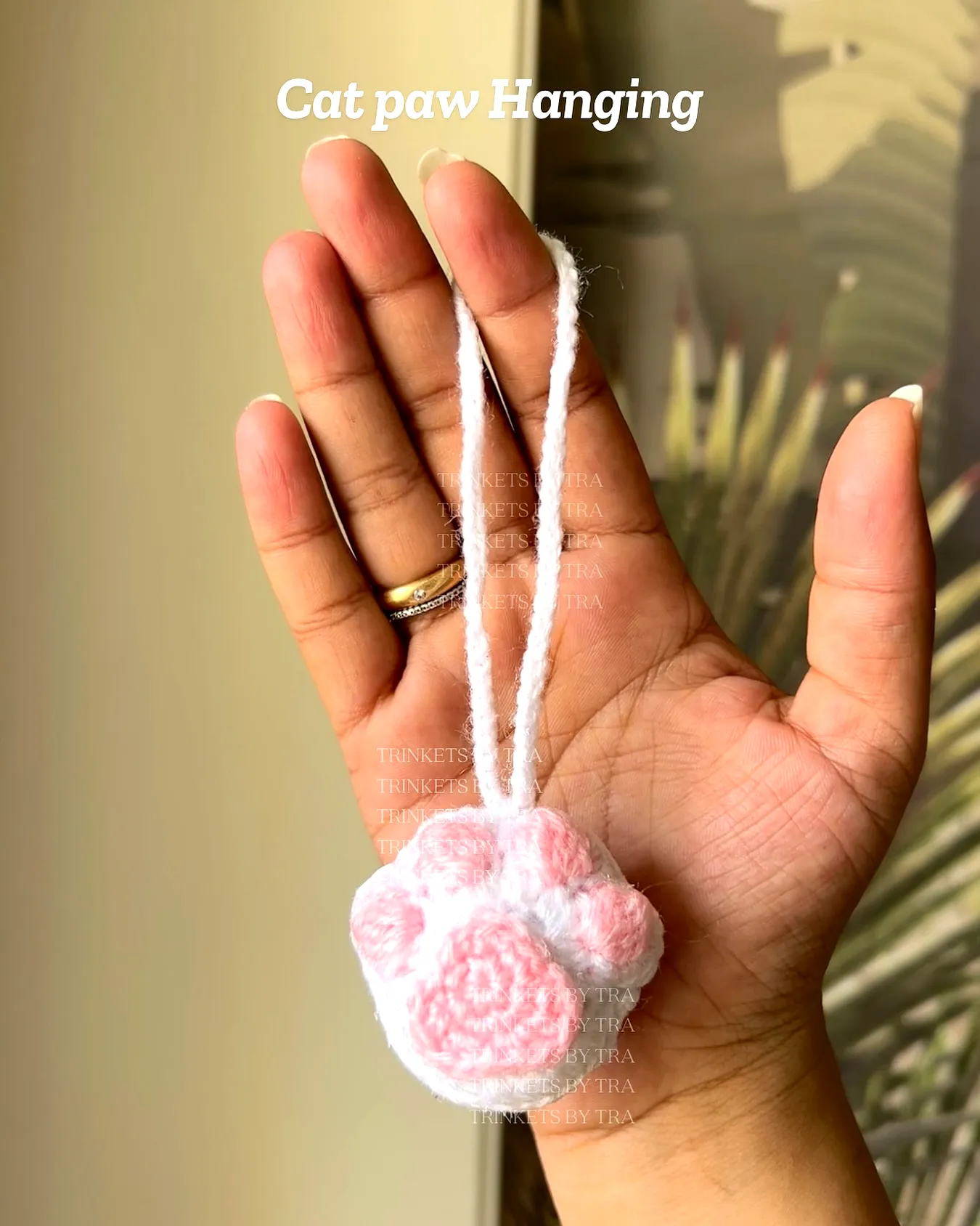 Cute pink and white crochet cat toy in paw design