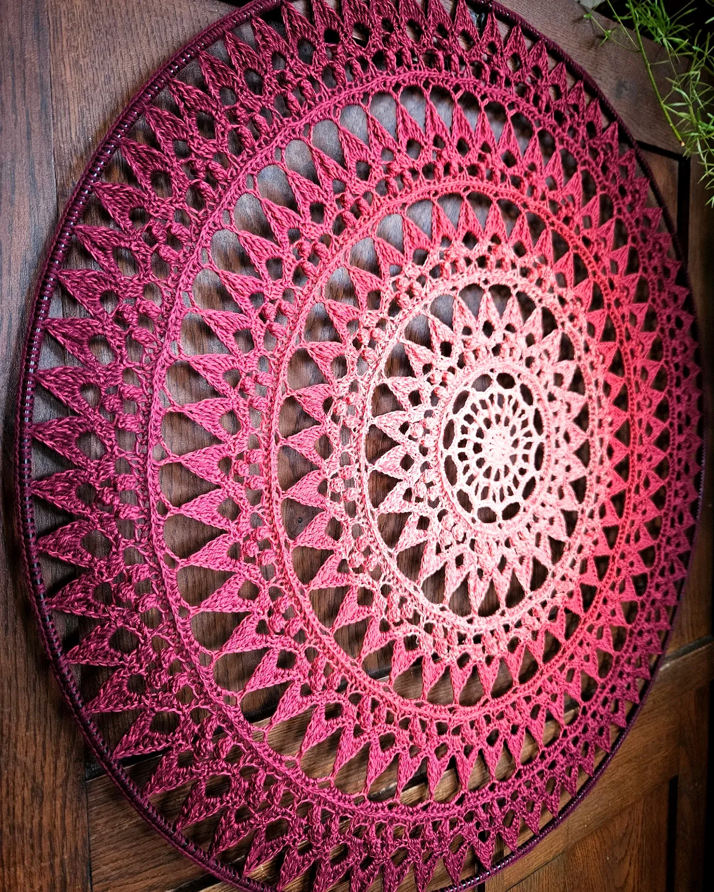 Intricate crochet mandala in gradient burgundy hues