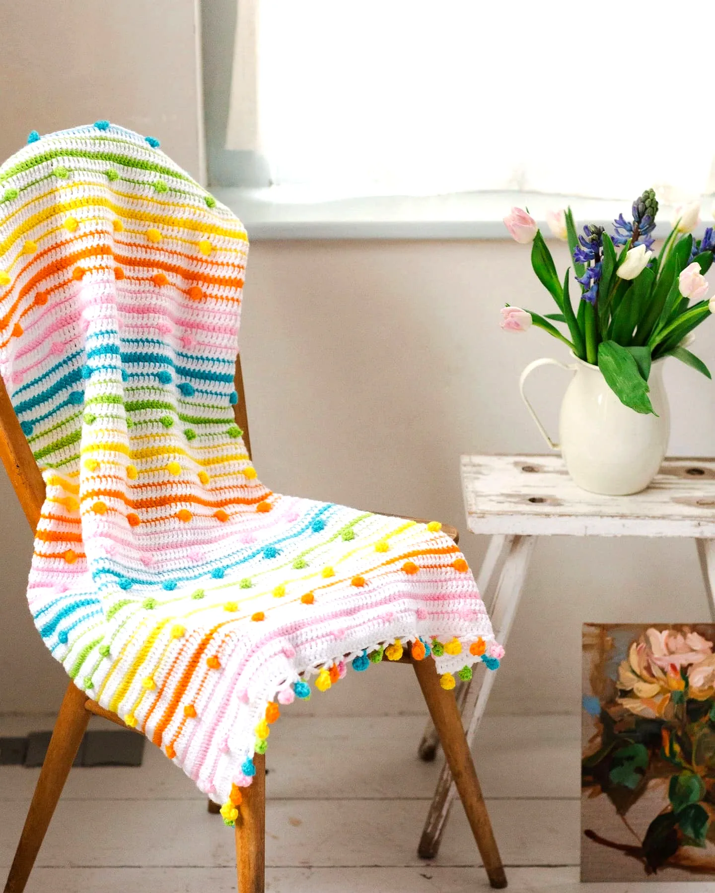 Vibrant Crochet Picnic Blanket with Pom-Poms and Pastel Stripes